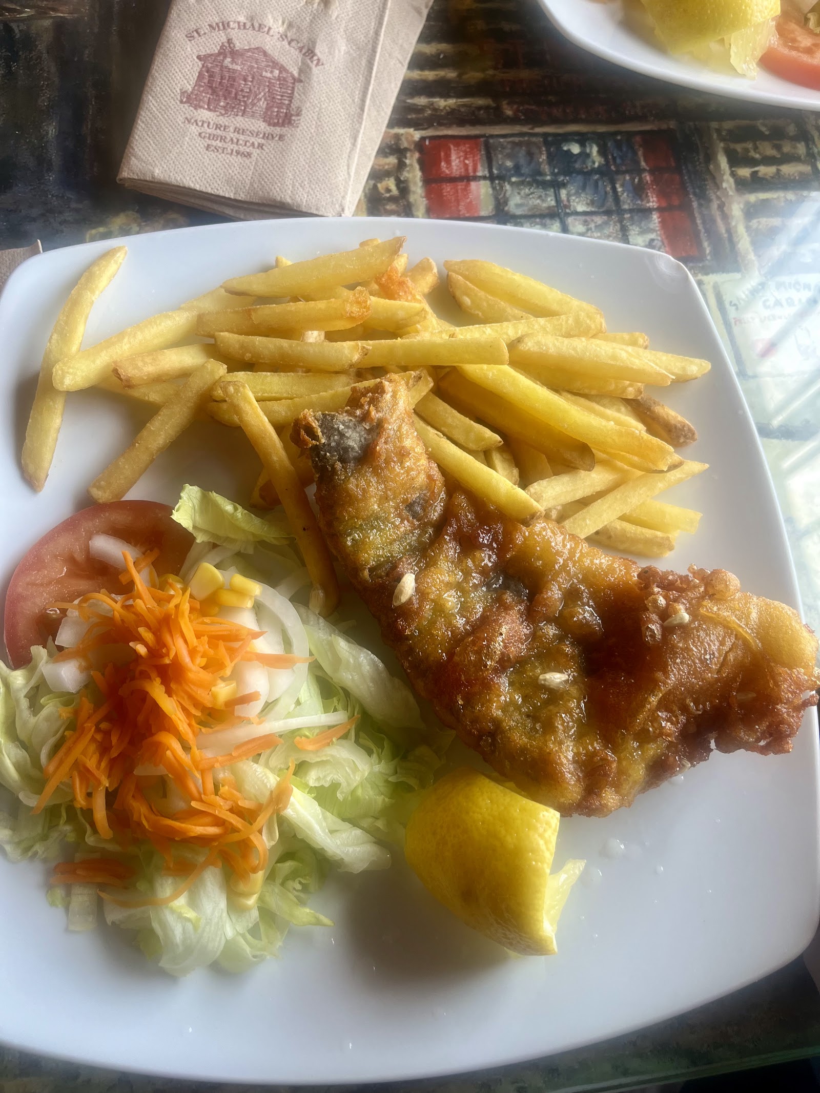 Fish and chips with salad and a Saint Michael's Cabin napkin