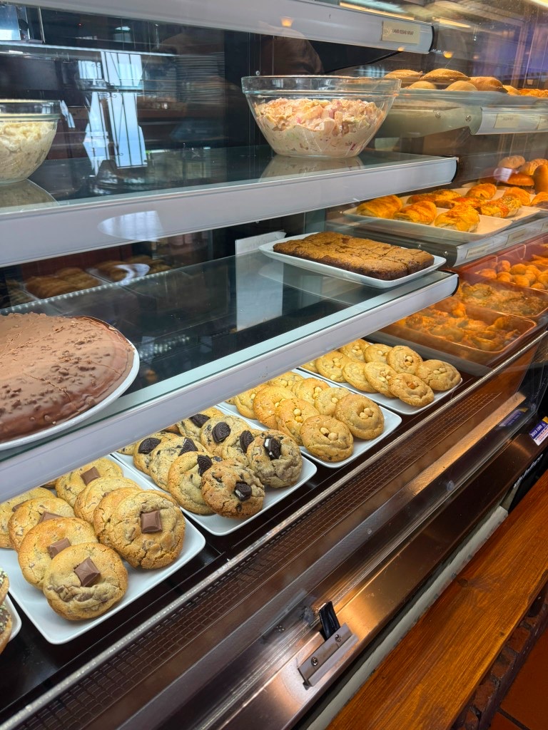 Display case with salads, chocolate cake and fresh cookies