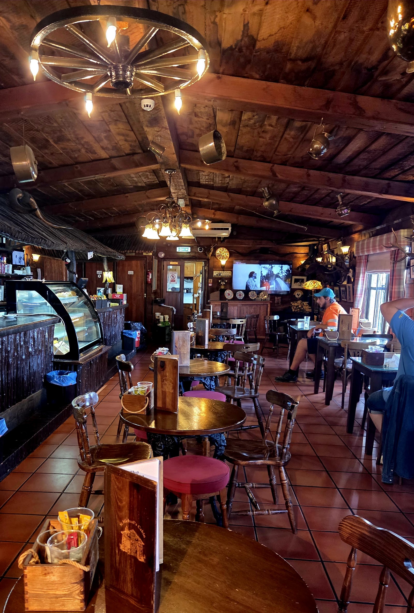 Dining room with a wagon-wheel chandelier and terracotta tiles